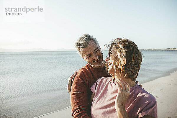 Glückliche blonde Frau und Mann genießen den Urlaub am Strand