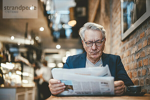 Geschäftsmann liest Zeitung im Café