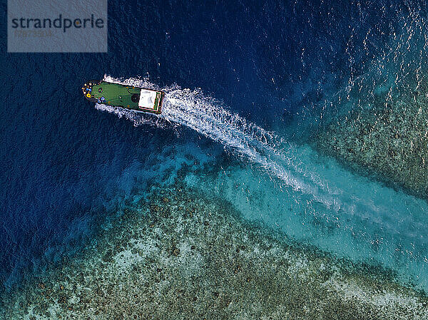 Maldives  Kaafu Atoll  Himmafushi  Aerial view of motorboat sailing across coastal water