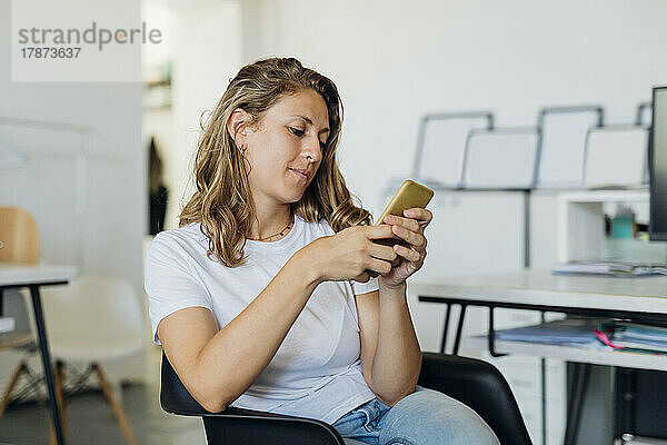 Geschäftsfrau benutzt Smartphone im Büro