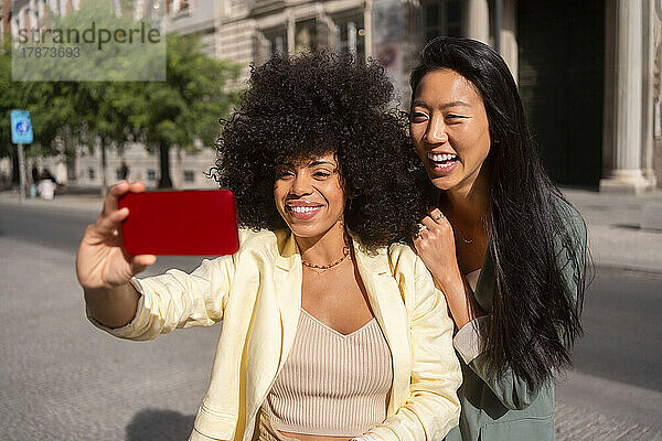 Fröhliche  gemischtrassige Freunde  die Selfies mit dem Smartphone machen