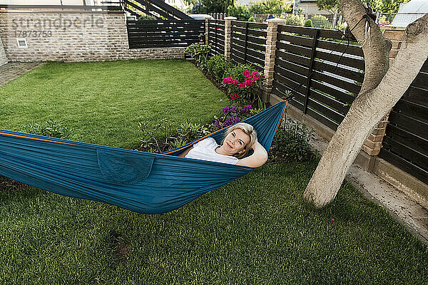 Reife Frau entspannt sich in der Hängematte im Garten