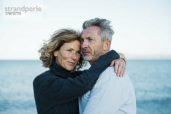 Lächelndes älteres Paar  das vor dem Meer steht