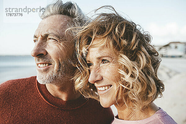 Glückliche blonde Frau und Mann verbringen gemeinsame Zeit am Strand