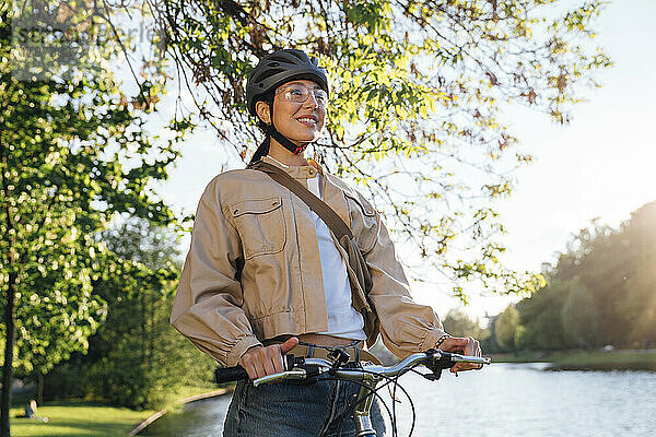 Lächelnde Frau mit Fahrrad im Park