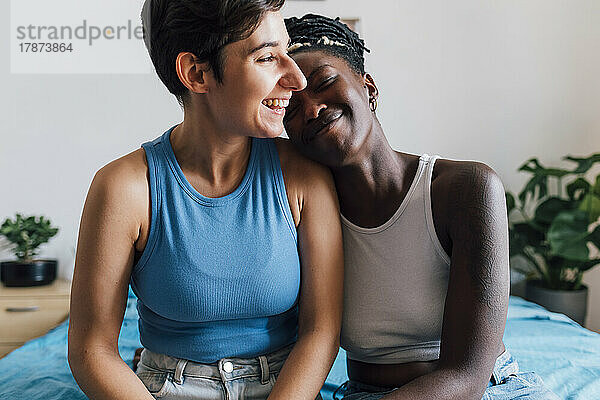 Glückliches lesbisches Paar  das zu Hause im Bett sitzt