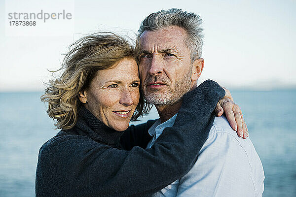 Älteres Paar vor dem Meer an einem sonnigen Tag