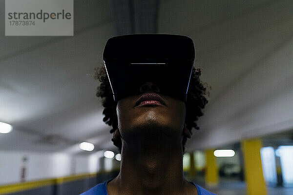 Junger Mann trägt Virtual-Reality-Headset am unterirdischen Gang