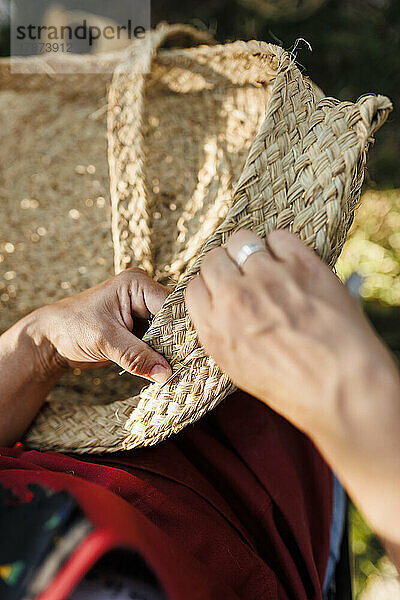 Hände einer Kunsthandwerkerin  die einen Korb aus Espartogras webt