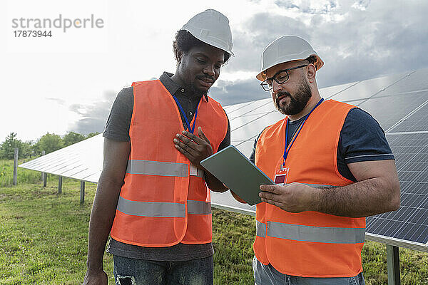 Ingenieure diskutieren mit Kollegen über Tablet-PC an Solarstation