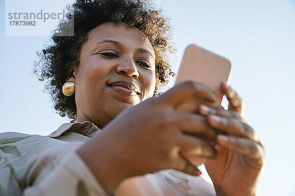 Lächelnde Geschäftsfrau  die Smartphone benutzt