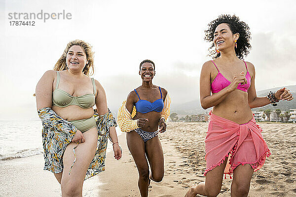 Sorglose gemischtrassige Frauen  die Spaß am Strand haben