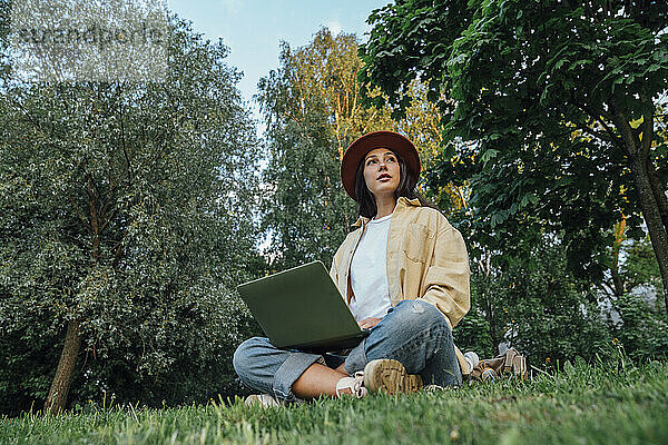 Nachdenklicher Freiberufler mit Laptop im Park