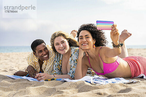Gemischtrassige Freunde machen am Strand ein Selfie mit dem Smartphone