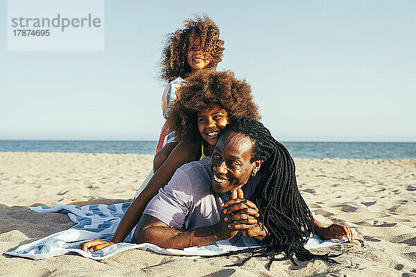 Glücklicher Mann mit Töchtern am Strand
