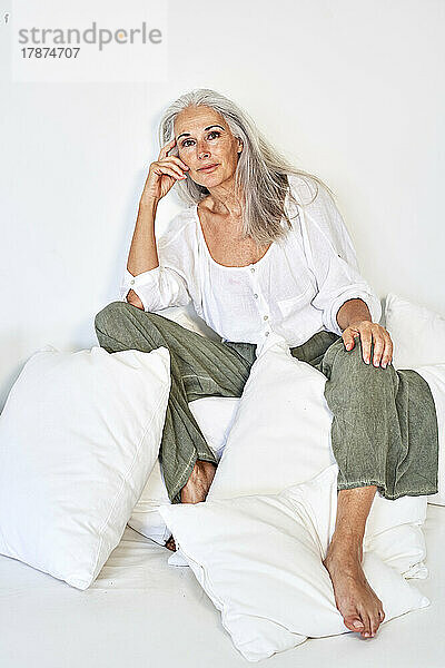 Frau mit grauen Haaren sitzt auf der Couch