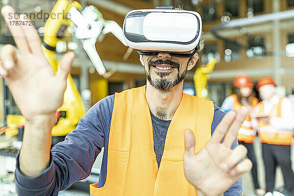 Industriearbeiter in einer Roboterfabrik mit Virtual-Reality-Simulator