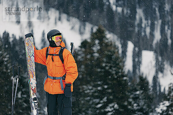 Glücklicher Mann mit Skiern  der den Winter genießt