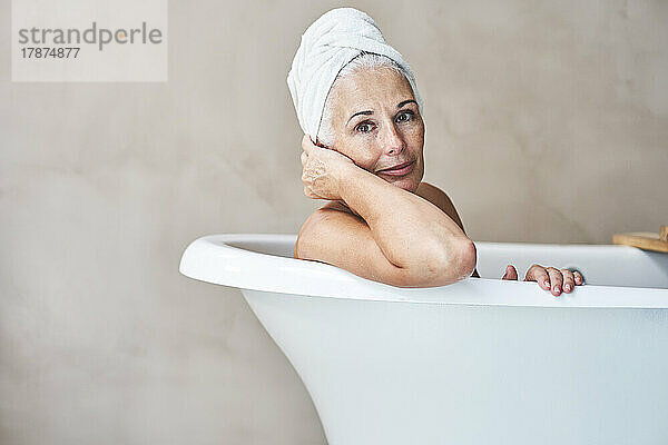 Smiling woman in bathtub at home