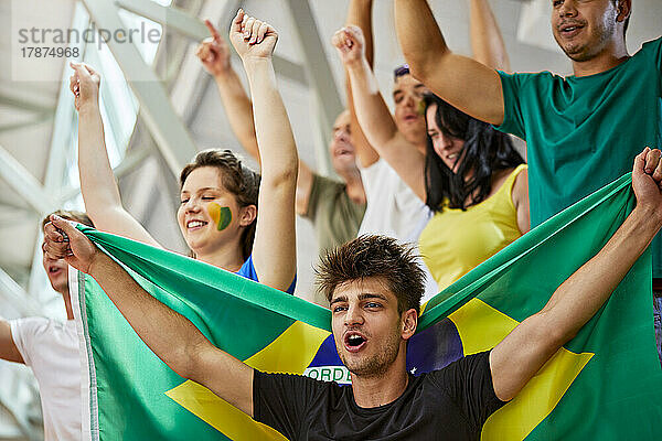 Fans mit Brasilien-Flagge rufen gemeinsam bei Sportveranstaltung im Stadion