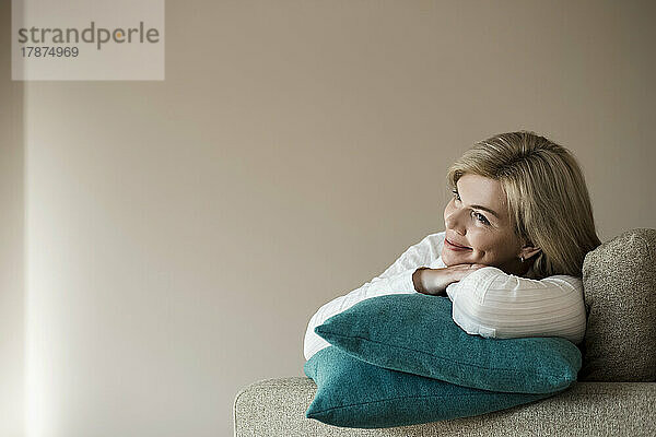 Thoughtful woman relaxing on couch at home