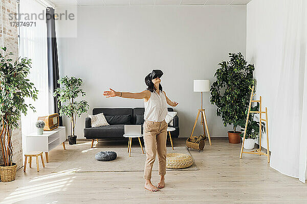 Frau nutzt Virtual-Reality-Simulator im heimischen Wohnzimmer