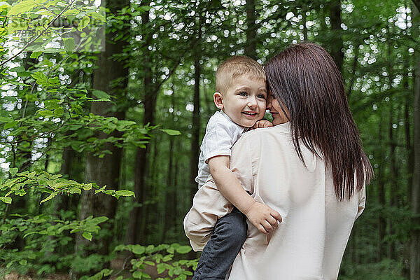 Happy mother and son in forest on vacation