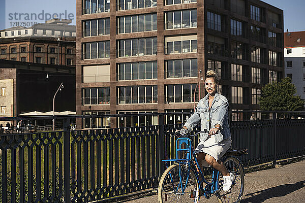 Glückliche junge Frau  die an einem sonnigen Tag Fahrrad fährt