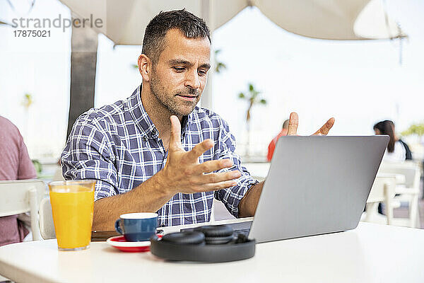 Reifer Freiberufler arbeitet am Laptop im Straßencafé