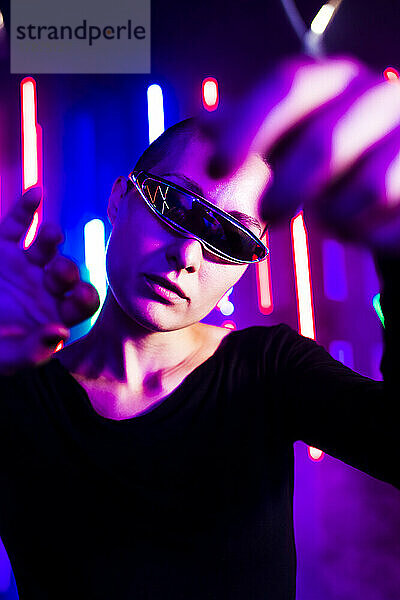 Hipster-Frau mit futuristischer Brille vor Neonlichtern