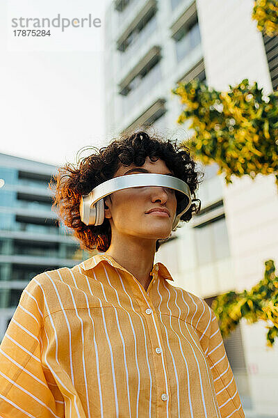 Junge Frau mit lockigem Haar und futuristischer Brille