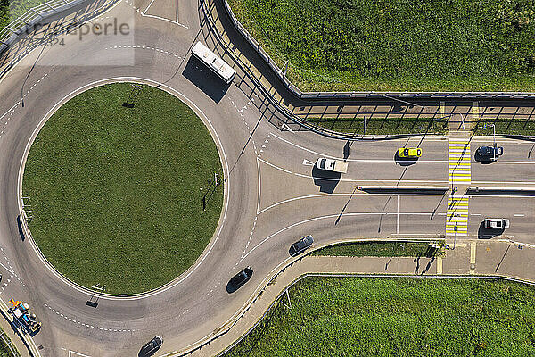 Luftaufnahme eines Kreisverkehrs inmitten von Gras an einem sonnigen Tag