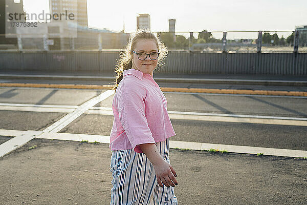 Selbstbewusstes Teenager-Mädchen mit Down-Syndrom  das auf der Straße läuft