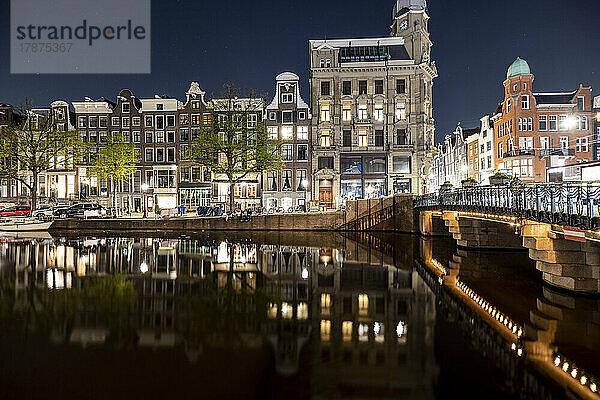 Niederlande  Nordholland  Amsterdam  Stadtkanal bei Nacht mit Reihenhäusern im Hintergrund