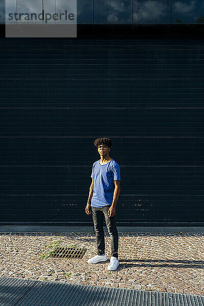 Young man standing in front of wall