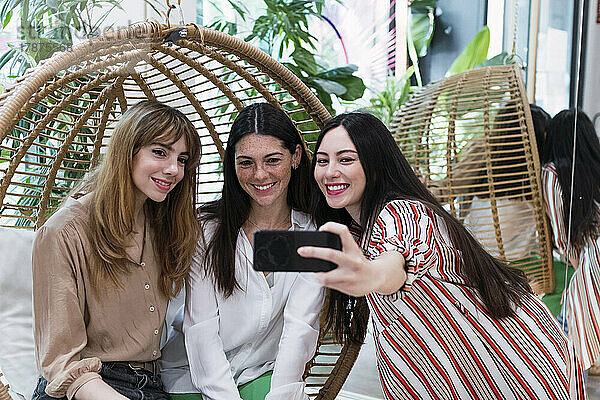 Drei Geschäftsfrauen machen ein Selfie im Hängesessel