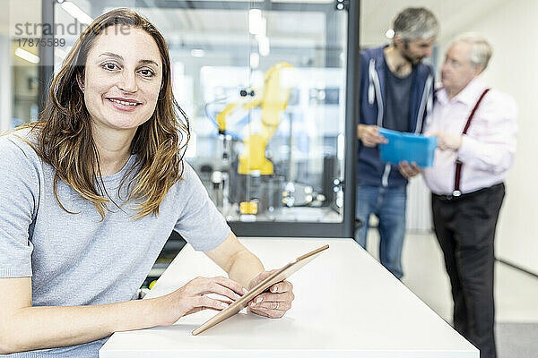 Frau arbeitet in einer Roboterfabrik mit digitalem Tablet