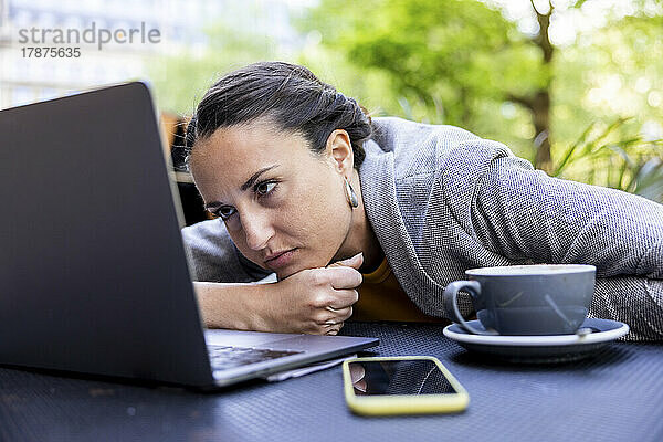 Traurige Geschäftsfrau schaut auf Laptop