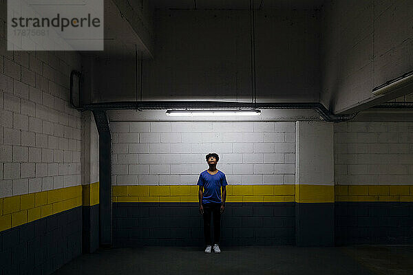 Junger Mann blickt in der U-Bahn auf LED-Licht