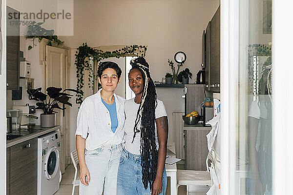 Lächelndes lesbisches Paar  das sich zu Hause umarmt