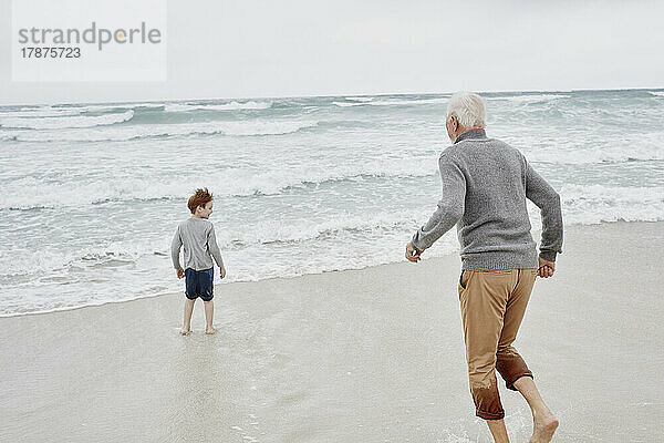 Großvater spielt mit Enkel am Meer