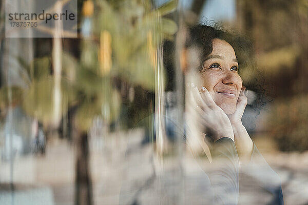 Lächelnde Frau durch Glas gesehen