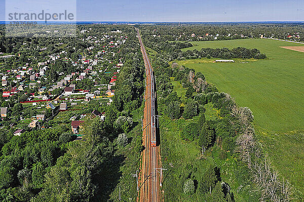 Aerial view of railroad tracks stretching along edge of rural town
