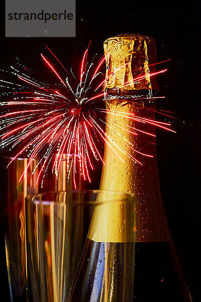 Flasche Champagner gegen explodierendes Feuerwerk