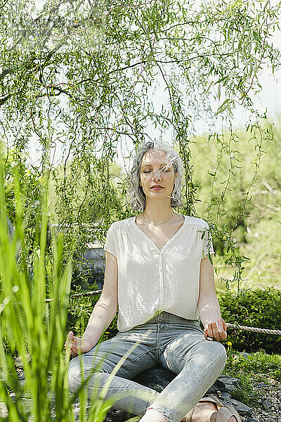 Frau praktiziert Yoga im Park