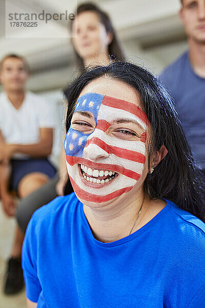 Glückliche Frau mit amerikanischer Flagge im Gesicht