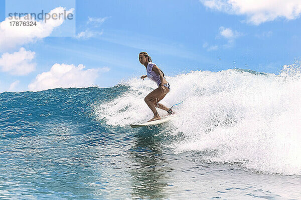Woman surfing on surfboard in sea