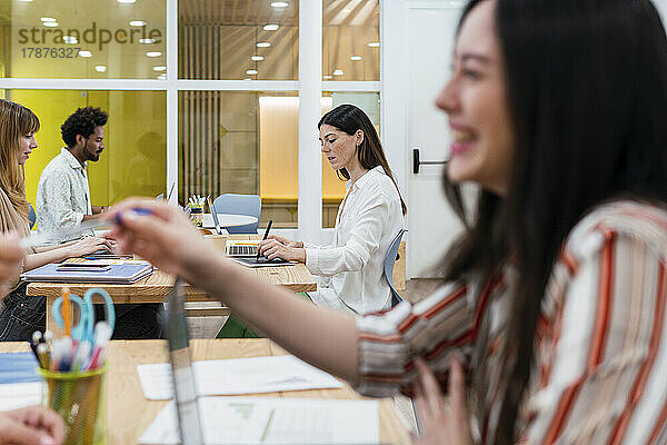 Geschäftsfrau übergibt Stift an Kollegen im Büro