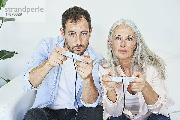 Mutter und Sohn spielen zu Hause Videospiele mit Gamecontrollern