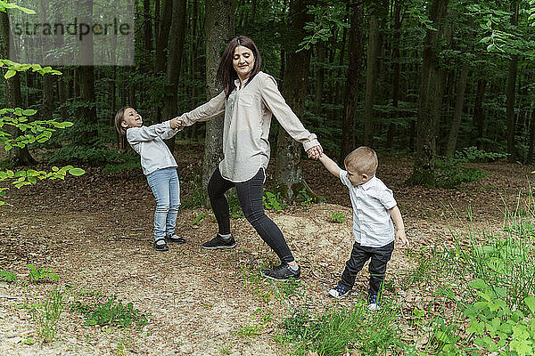 Mutter mit Sohn und Tochter spielen im Wald